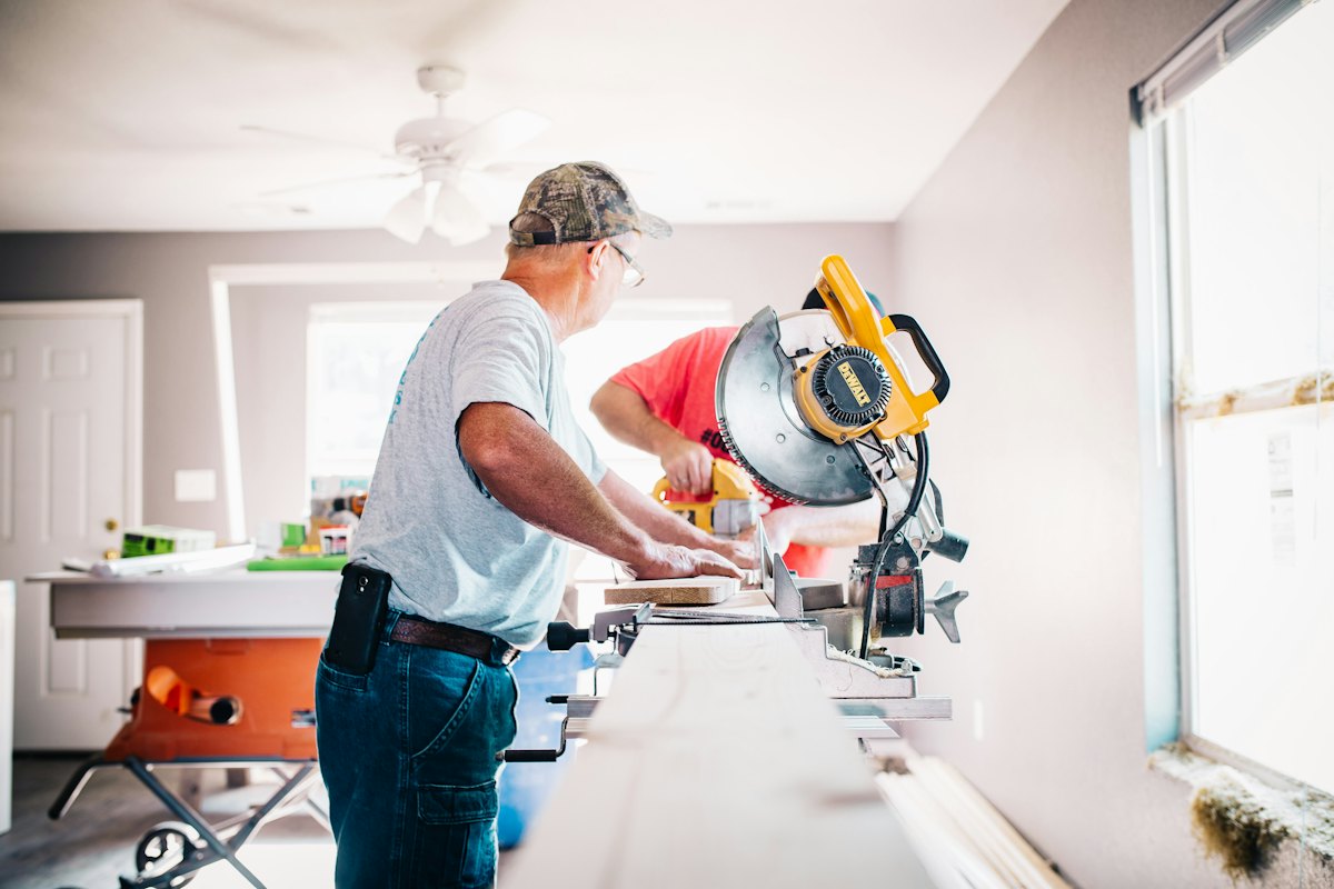 Contractor cutting trim with a miter saw